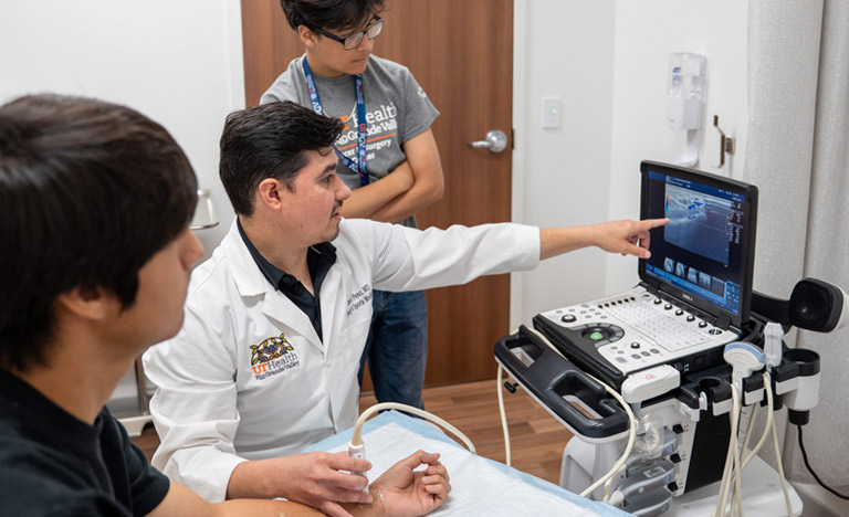 Doctor in a white coat points at an ultrasound image on ...