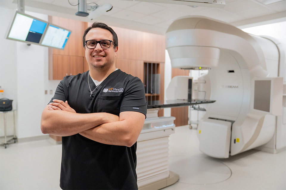 Antonio Martinez Jr., medical dosimetrist at UT Health RGV, stands in front of "Eve," one of the new TrueBeam radiation treatment systems at the UT Health RGV Cancer and Surgery Center. 
