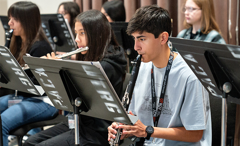 A young male musician plays a wind instrument in a ...