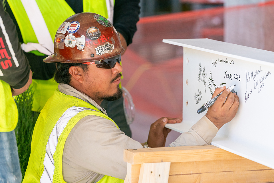 Construction worker signs steal beam