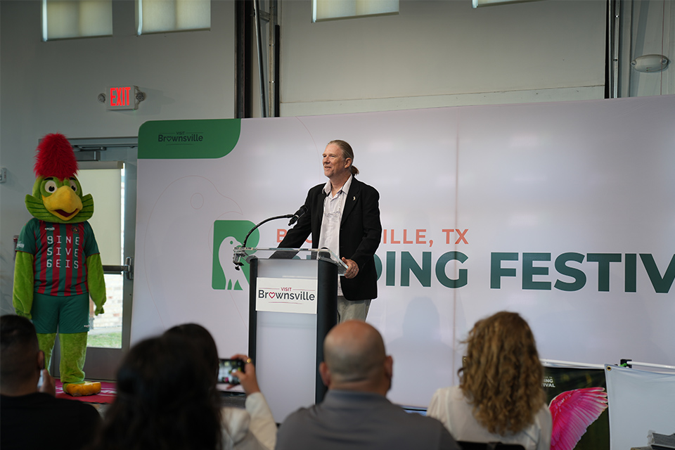 Dr. Karl Berg speaks at a March 12 press conference about the upcoming Brownsville Birding Festival. He highlights UTRGV's role in promoting local bird diversity and conservation. The festival is set for April 11–12, featuring educational programs and birding tours.