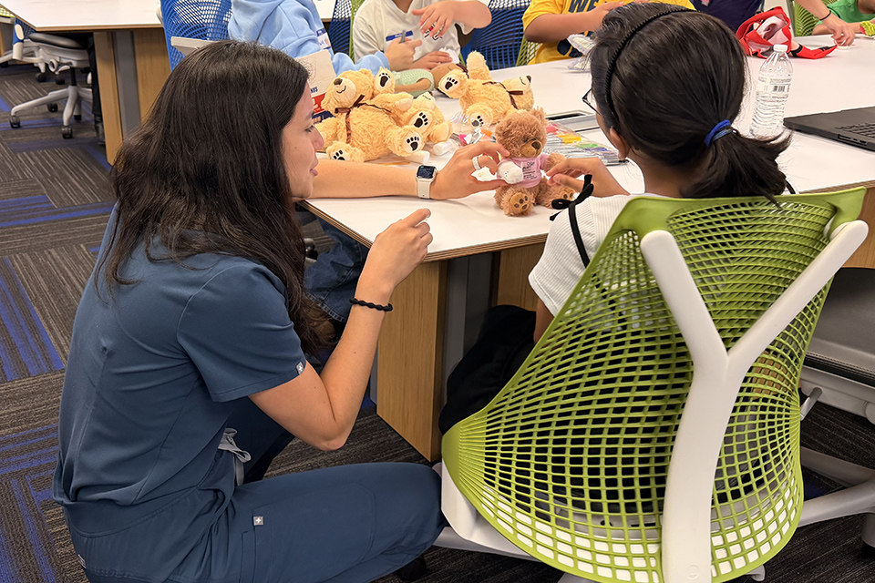 UTRGV School of Medicine students and volunteers work with children during a RISE outreach event featuring hands-on science and health care activities.