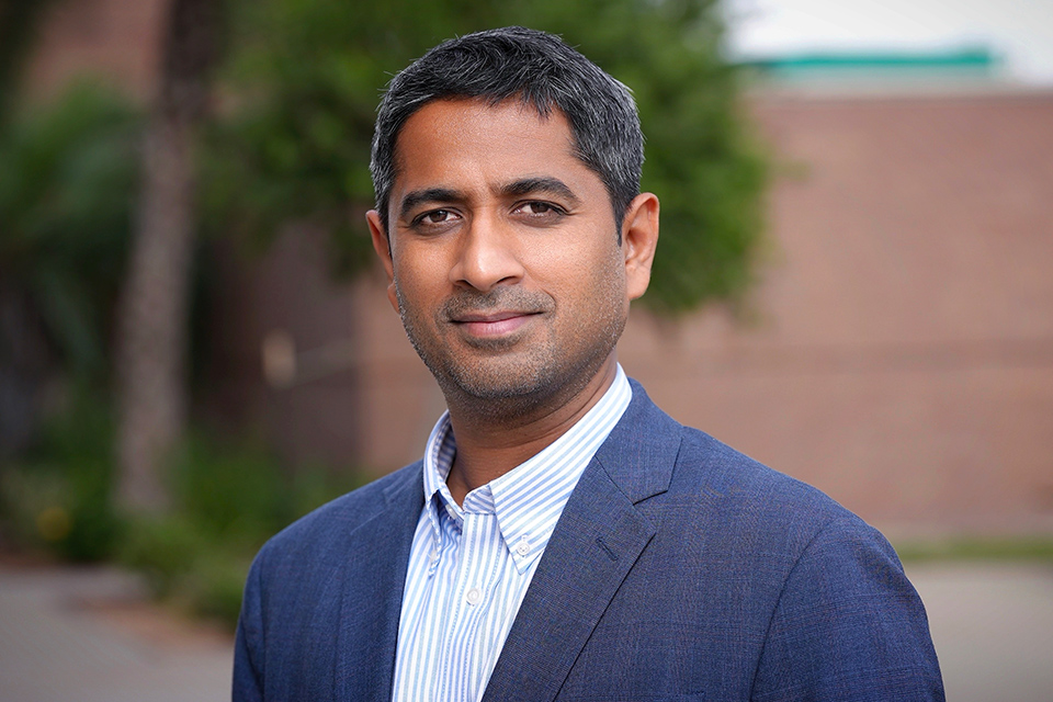 Head-and-shoulders portrait of Arya Singh wearing a blue blazer and striped shirt outdoors on the UTRGV campus.