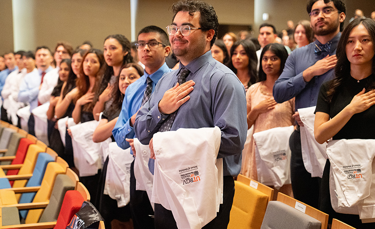 UTRGV School of Medicine students hold white coats and ...