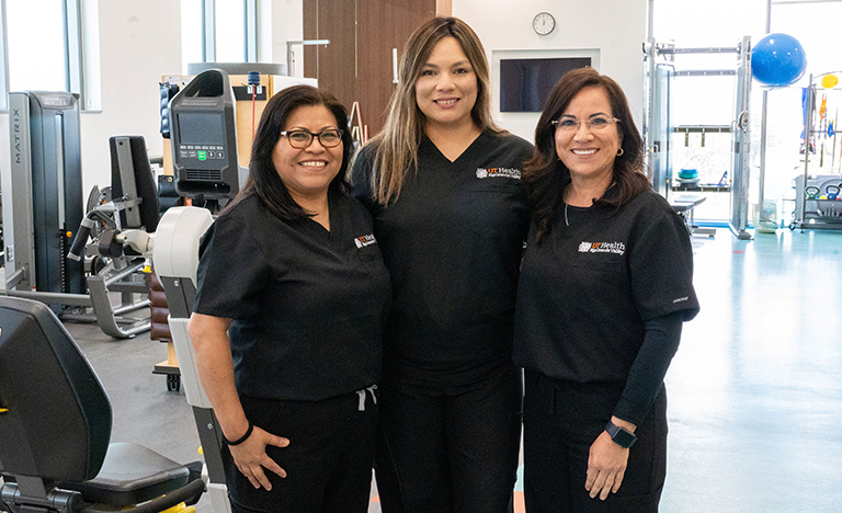 Three smiling women in matching black uniforms with ...