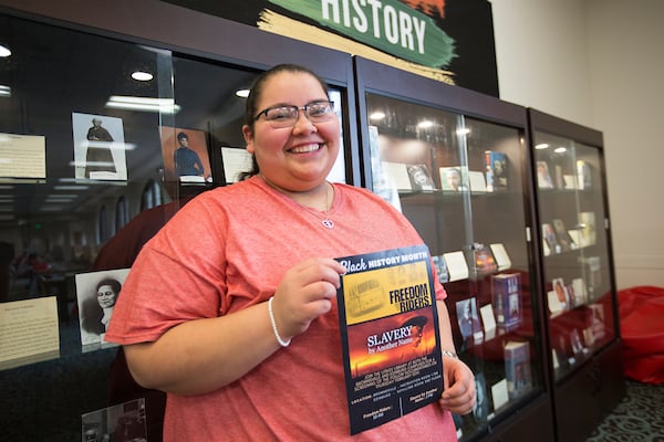 Woman shows Black History Month Freedom Riders poster.