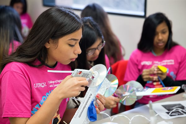 High school female students build balloon powered cars.