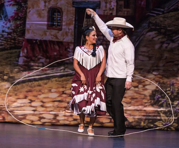 Vaquero dancer using a lazo around a woman.