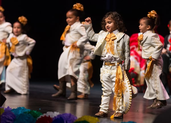 Little boy dressed in charro costume dances for the audience.