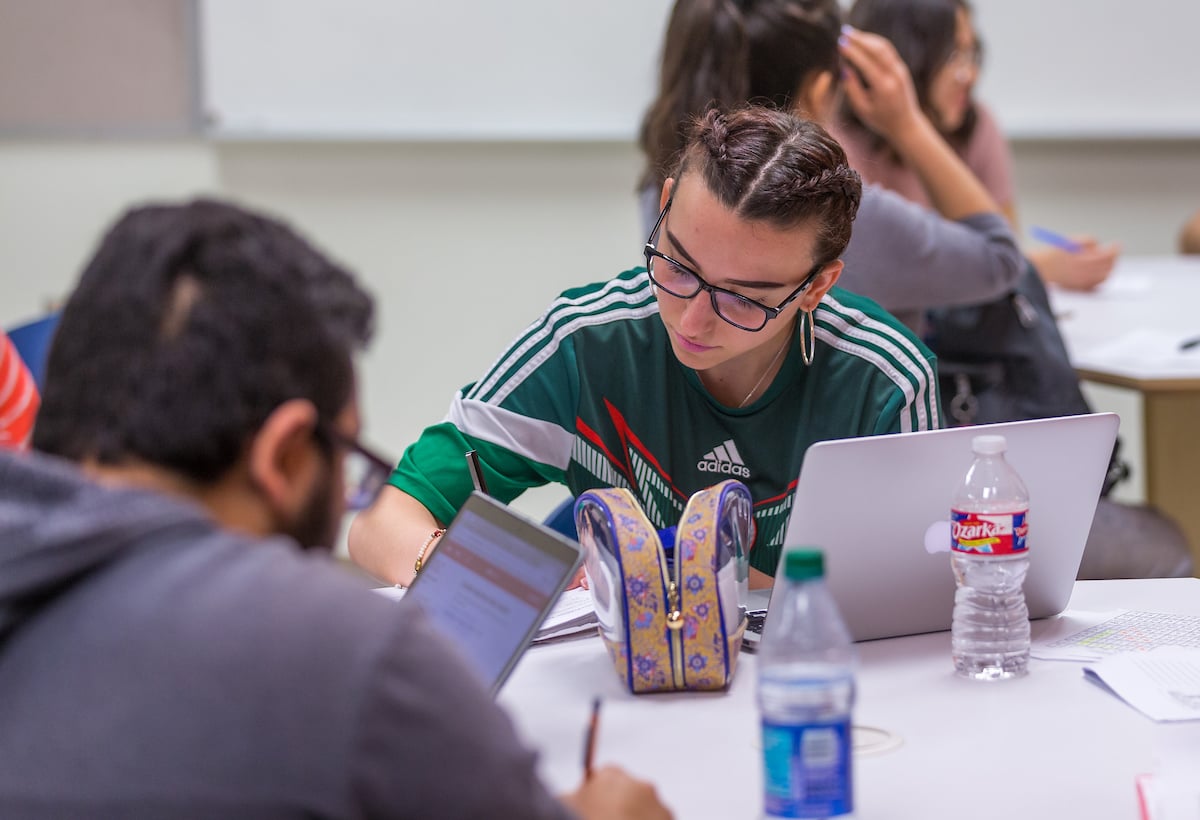 Female student writes down notes.