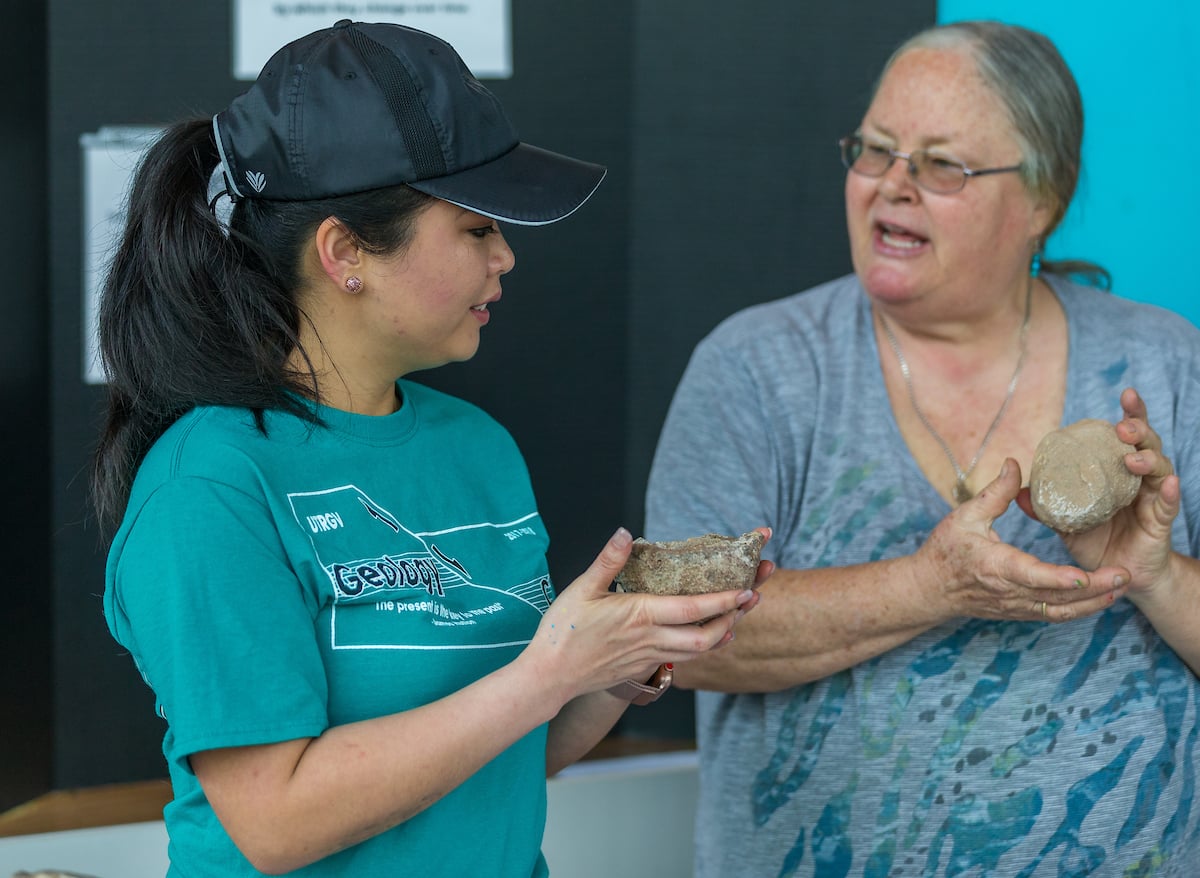 Professor examines rock specimens.