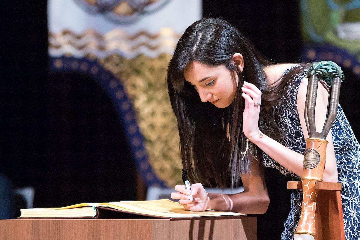 A student signs the register.