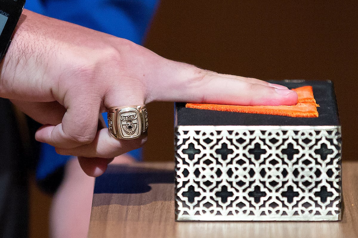 A student inks their fingers.