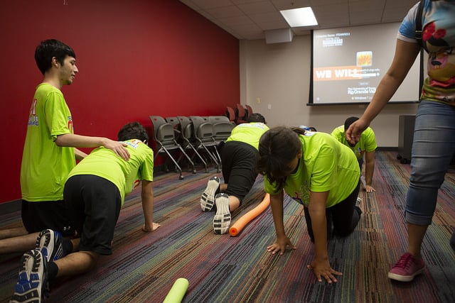 Team Mario summer camp participants crawl on the floor during an exercise.