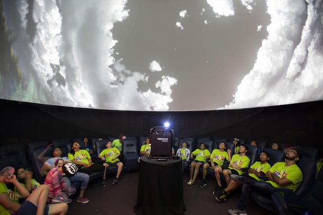 Team Mario summer camp members look at projection of sky.