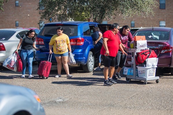 Freshman carrying luggage, bags and boxes for move-in day.