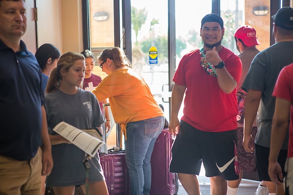 Freshman shows a thumb's up and smiles for photo.