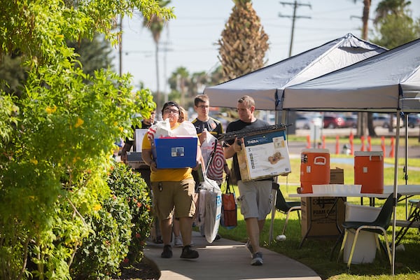 Freshman carry boxes to the dorms on move-in day.