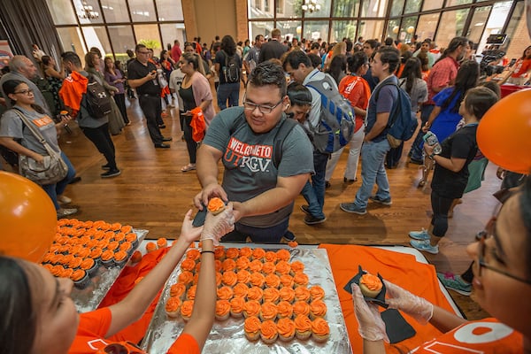 Student recieving a cupcake on UTRGV Day.