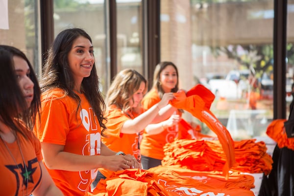 Victoria Villela, Account Executive handing out free shirts on UTRGV Day.