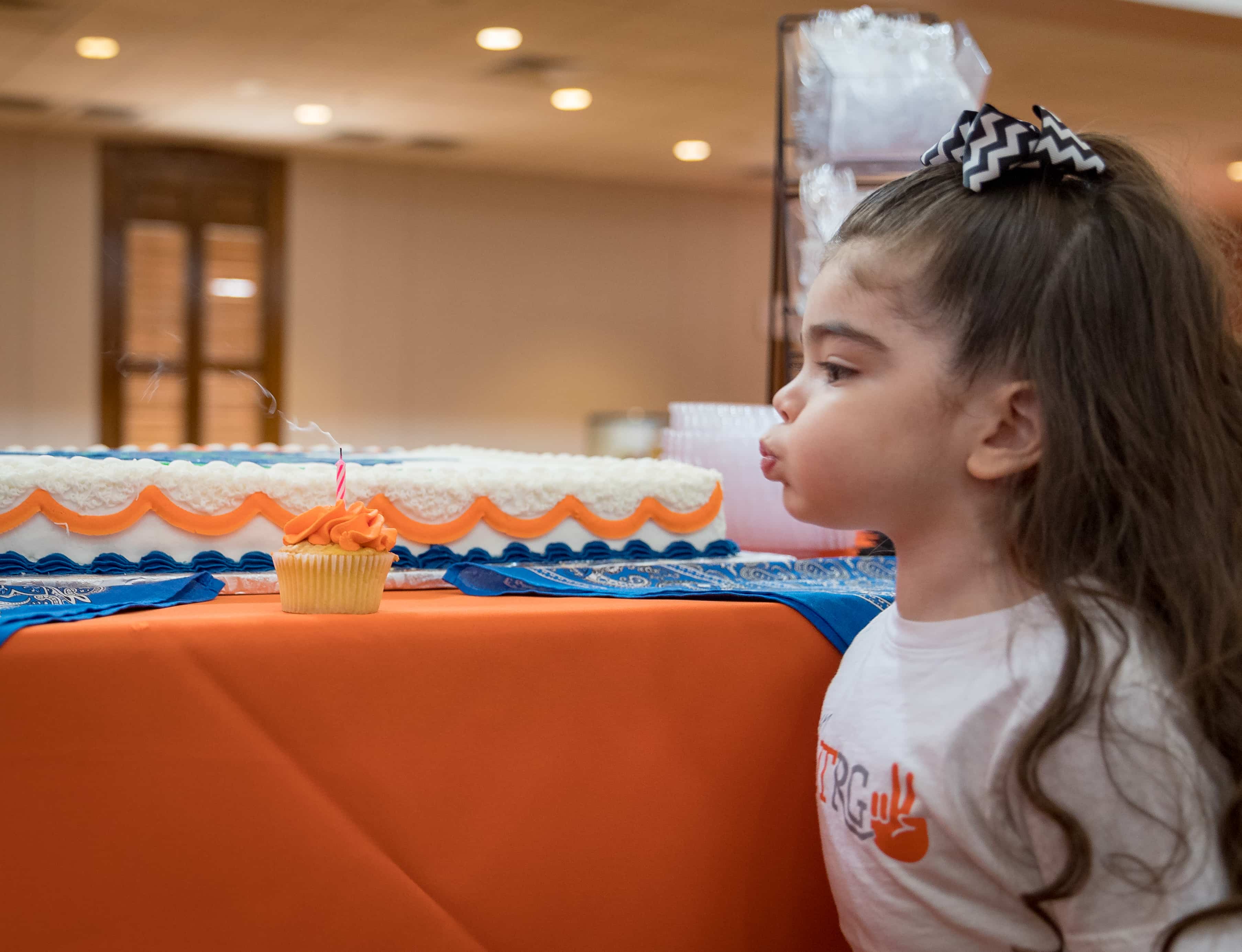 Baby Ava blows out candle.