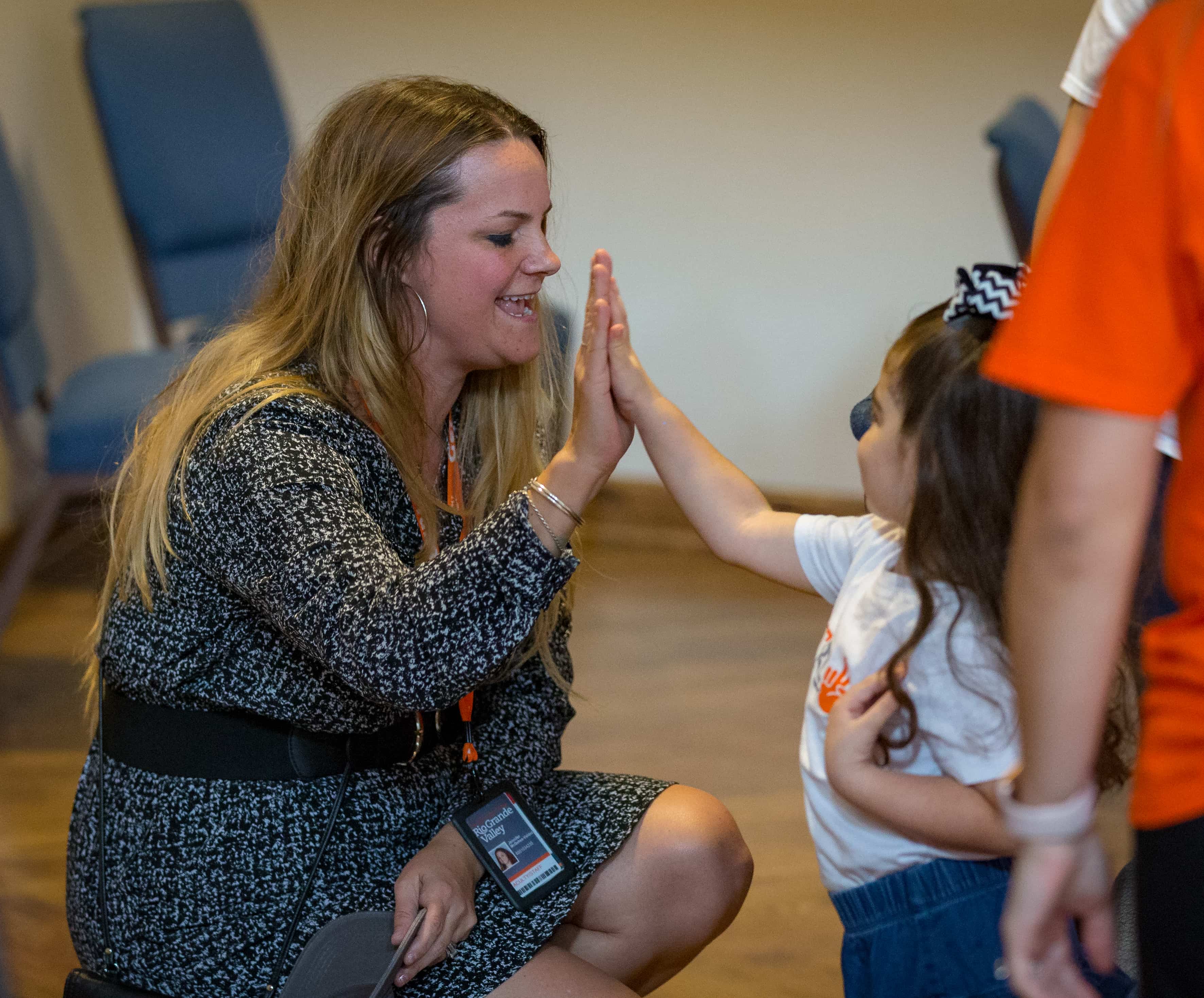 Jennifer McGehee-Valdez, Director of Public Relations high five's Ava on UTRGV Day.