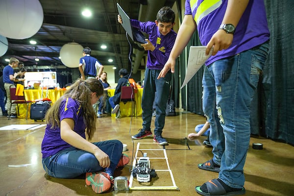 Students take robot through obstacle.