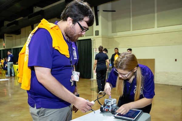 Coach helps student test their machine.