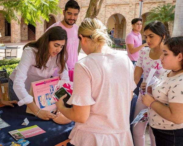 Demonstrating how to do a breast self-exam.