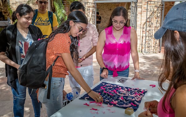 Students pick up pink ribbons in support of cause.