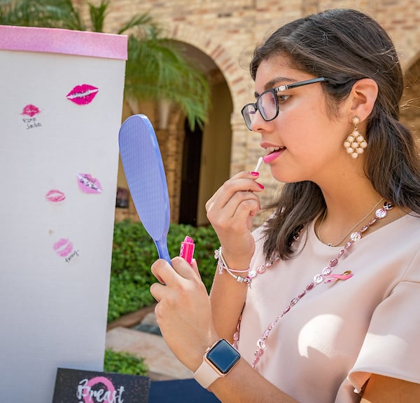 A student puts on lipstick to kiss the board.