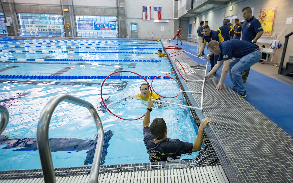 Members of the U.S. Navy prepare the course for competition.