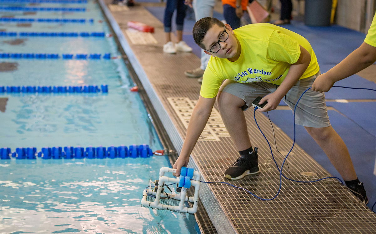 Student gets ready to submerge robot.
