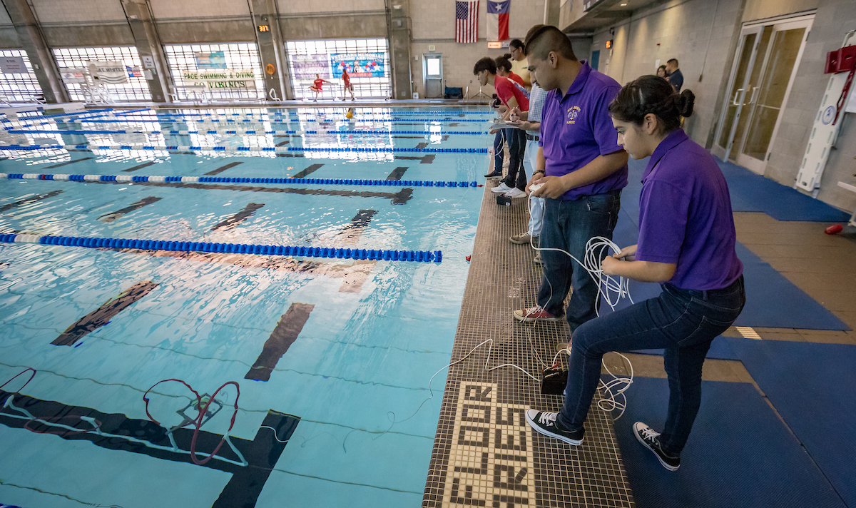 The teams work hard to get their robots through obstacle course.