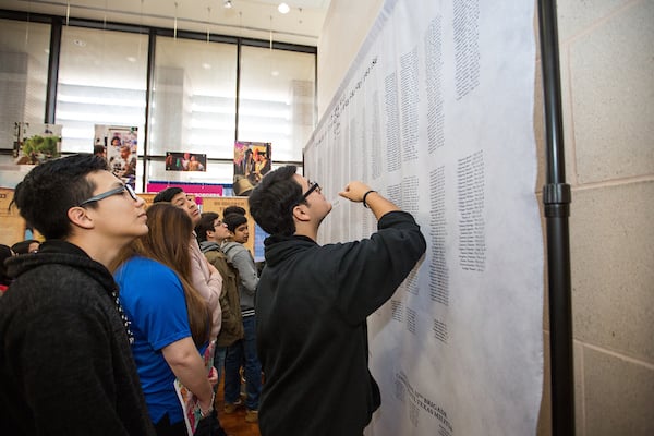 Thumbnail: Guests read names of fallen at the exhibit