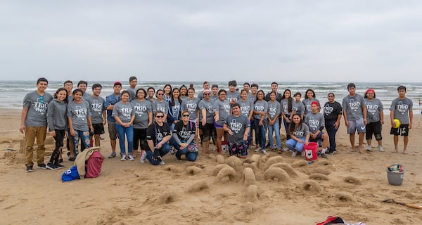 A group of students pose with their octopus sand creature