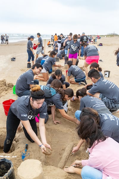 Trio students learning how to build sandcastles