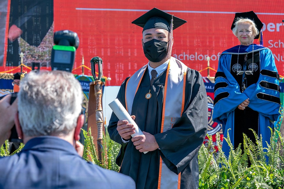 graduate holding his diploma