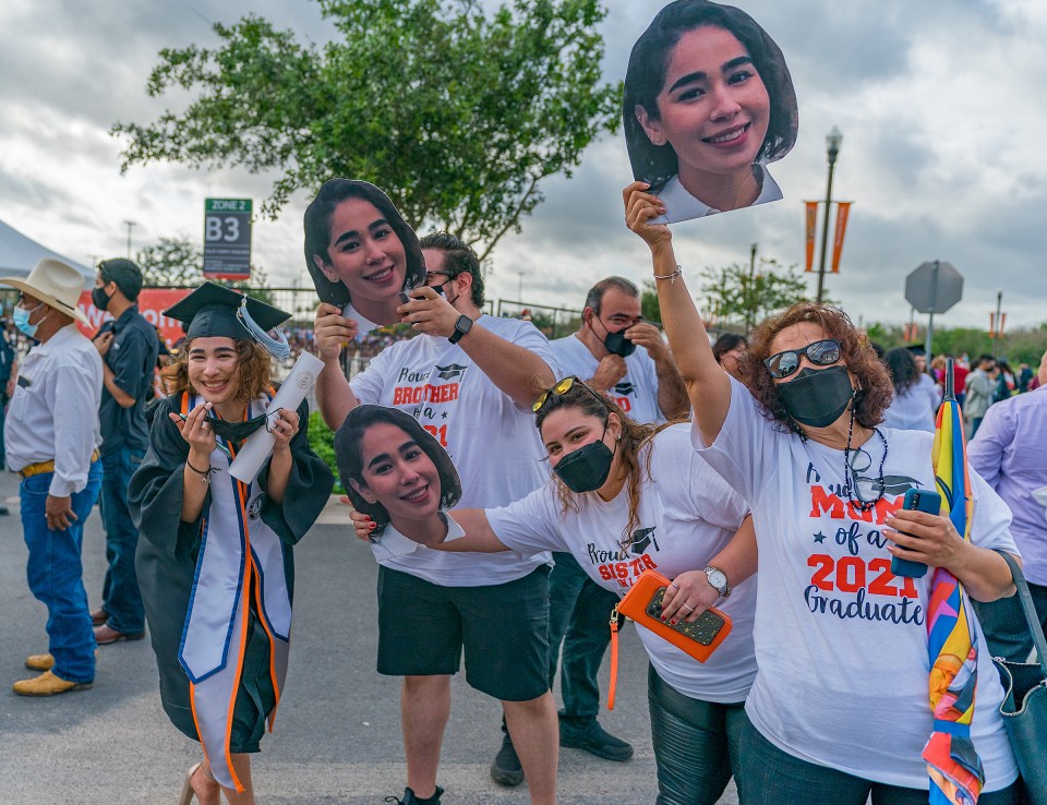 family members of graduate holding face cutouts