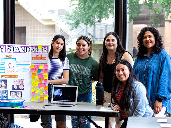 NovaRhet 2023   Students standing by table display at NovaRhet 2026