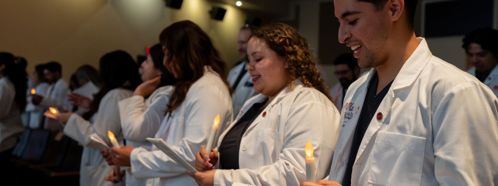 Students holding candles during ceremony.