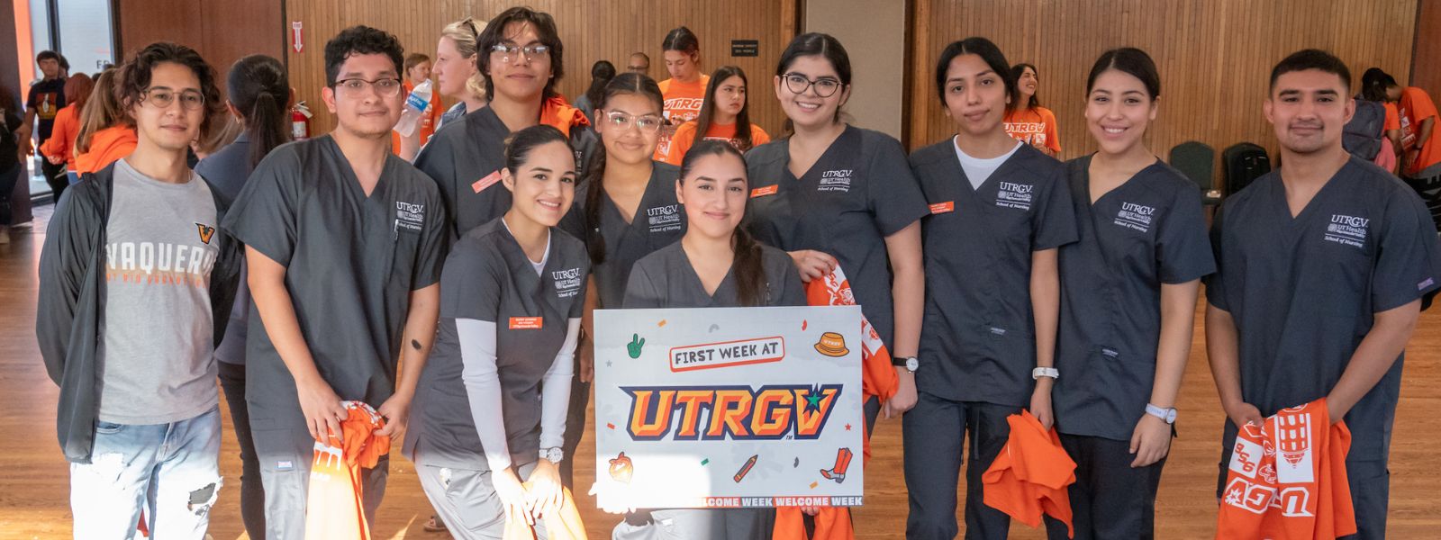 Nursing students posing for photo and signaling for v's up while in event.