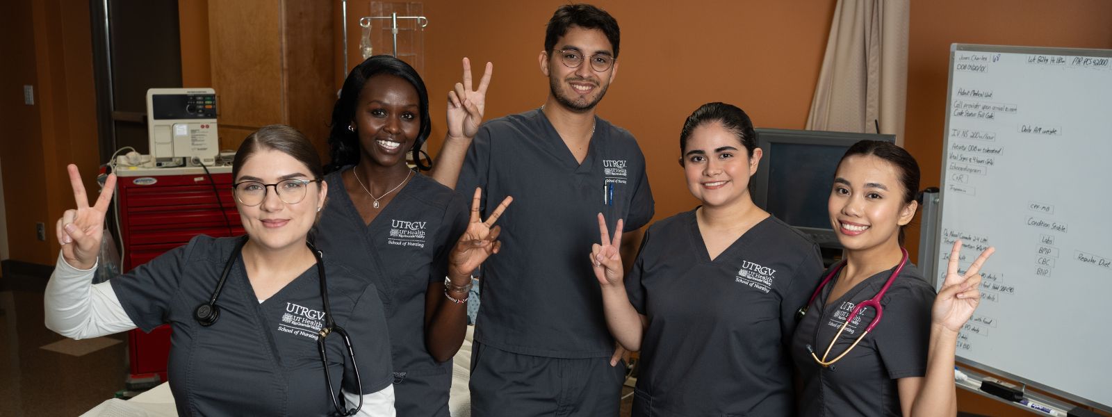 Group of nursing students signaling v's up.