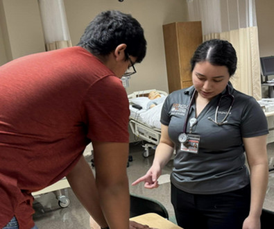 Nursing student assisting student.