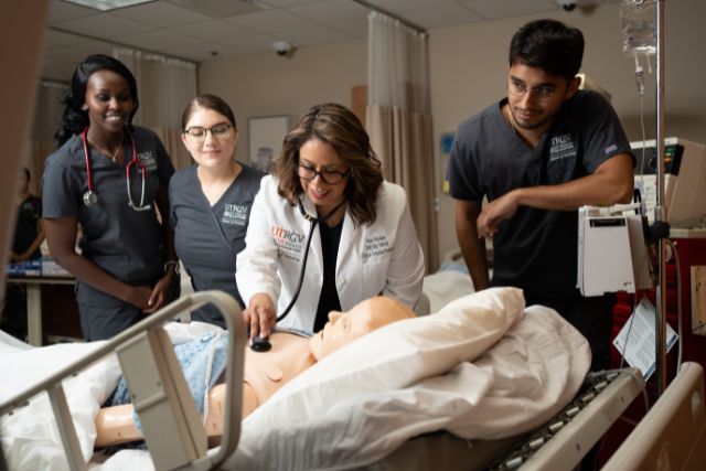 Nursing students being assisted by a faculty.