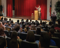 Auditorium filled with guests sitting.