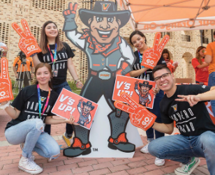 UTRGV students and staff group photo signaling v's up with university mascot.