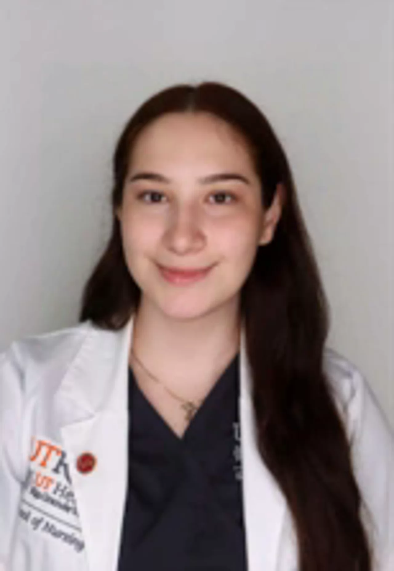 Portrait of Dayanara Cantu wearing a white UTRGV School of Nursing lab coat, smiling at the camera against a light background.