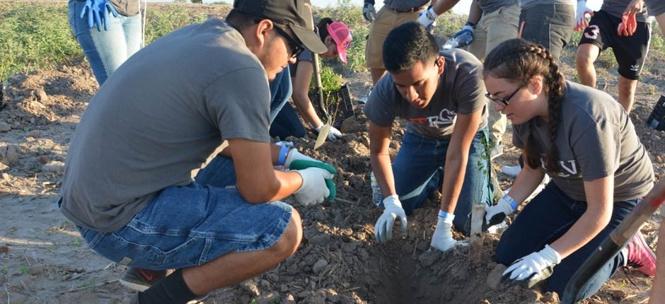 Abriendo Caminos Students at a community event planting trees