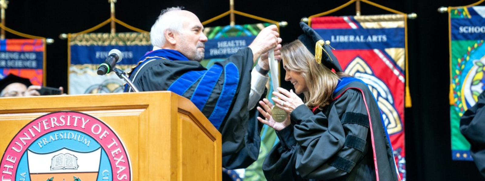 Dr. Arney receiving medal from Dr. Bailey on stage.
